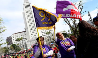 Members of the school workers union hold up flags as thousands rally on March 15 in front of Los Angeles City Hall.