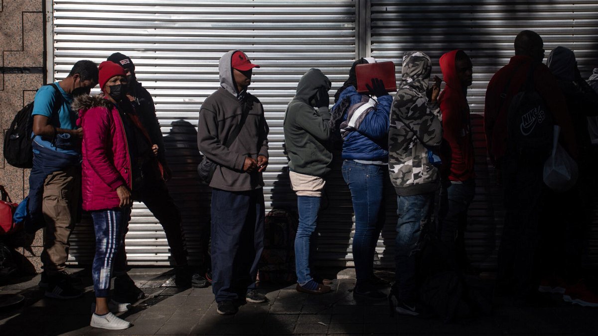 <i>Daniel Cardenas/Anadolu Agency via Getty Images</i><br/>Migrants wait in line outside at the Mexican Commission for Refugee Assistance in Mexico City