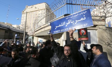 An Iranian protester holds a street sign bearing the name of prominent Shiite Muslim cleric Nimr al-Nimr during a demonstration against his execution by Saudi authorities
