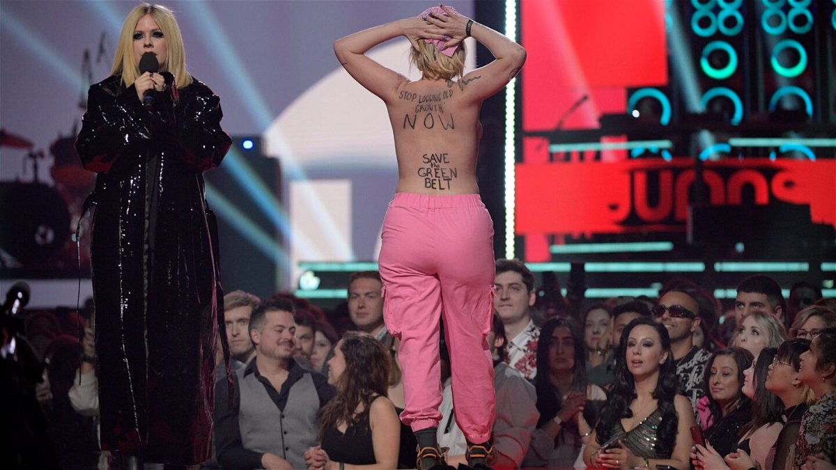 <i>Dale MacMillan/Getty Images</i><br/>A naked protestor interrupts Avril Lavigne speaking onstage at the 2023 Juno Awards.