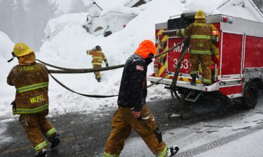 Mammoth Lakes Fire Department firefighters respond to a propane heater leak and small fire at a shuttered restaurant surrounded by snowbanks Sunday in Mammoth Lakes