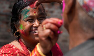 People apply colored powder on each other during Holi celebrations in Bhaktapur
