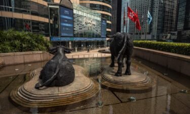 A woman walks past Exchange Square which houses the Hong Kong Stock Exchange in Hong Kong on April 27