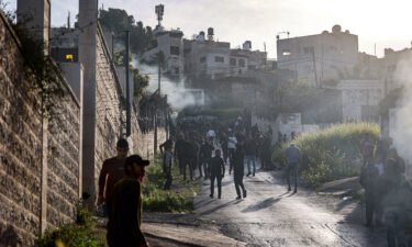 People gather along a road during an Israeli military raid in the Jenin camp for Palestinian refugees in the West Bank on Tuesday.