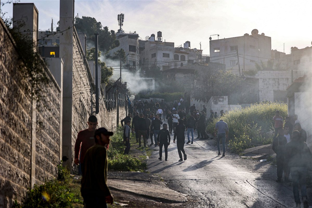 <i>Jaafar Ashtiyeh/AFP/Getty Images</i><br/>People gather along a road during an Israeli military raid in the Jenin camp for Palestinian refugees in the West Bank on Tuesday.