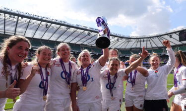 England's flanker and captain Marlie Packer celebrates with the trophy and teammates.