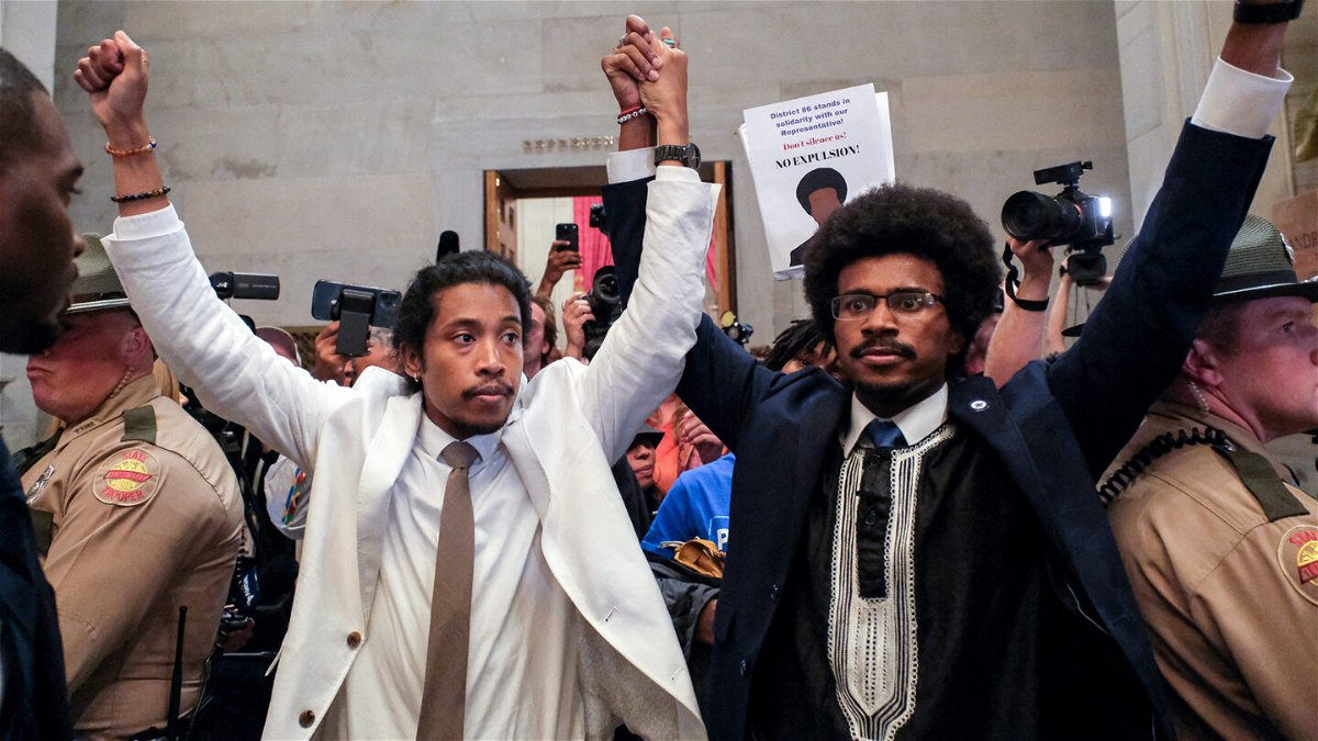<i>Kevin Wurm/Reuters</i><br/>Justin Pearson and Justin Jones raise their hands after being expelled from their seats in the Tennessee House in Nashville Thursday.