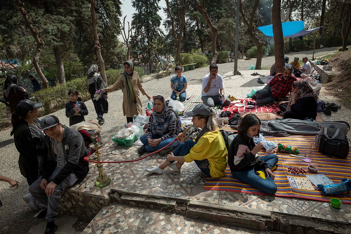 <i>Morteza Nikoubazl/NurPhoto/Getty Images</i><br/>An Iranian young woman puffs on a hookah as she and her family sit together in a park in northern Tehran during the day of Sizdah Bedar