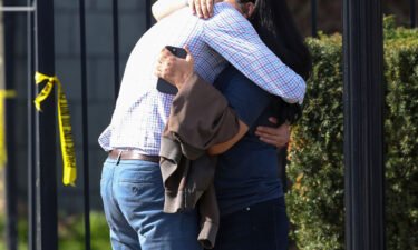 Two people embrace outside the building where a mass shooting happened in Louisville on Monday.