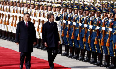 Chinese President Xi Jinping and French President Emmanuel Macron review troops during an official ceremony at the Great Hall of the People