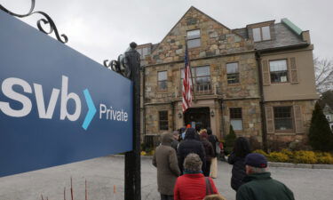 Customers wait in line outside a branch of the Silicon Valley Bank in Wellesley