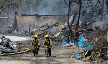 Firefighters walk out of the site of the recycling plant fire in Richmond