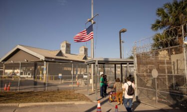 The U.S. flag flies at half-staff at a port of entry at the U.S.-Mexico border in February 2021 in Brownsville