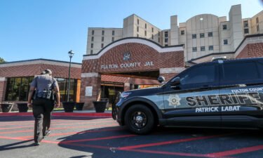 A Fulton County sheriff's deputy walks toward the entrance of the county jail in September 2022.  Fulton County Sheriff Patrick "Pat" Labat announced measures "to address an outbreak of infectious illnesses" at the county jail on April 14.