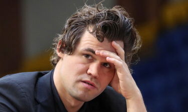 Magnus Carlsen sits in front of a chess board during a game at the World Rapid and Blitz Championships 2022 in Almaty