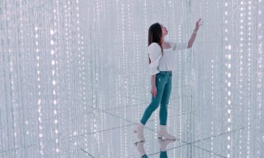 A woman poses for pictures inside the teamLab SuperNature museum at the Venetian Macao resort and casino in Macao