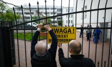 City officials put up a warning sign on the gate of a Russian embassy in Warsaw