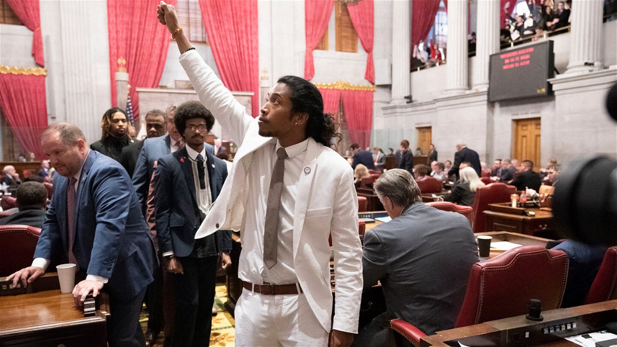 <i>George Walker IV/AP</i><br/>Justin Jones raises his fist on the floor of the House chamber as he walks to his desk to collect his belongings after being expelled from the legislature on Thursday