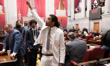 Justin Jones raises his fist on the floor of the House chamber as he walks to his desk to collect his belongings after being expelled from the legislature on Thursday