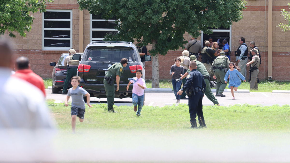 <i>Pete Luna/Uvalde Leader-News</i><br/>Students run to safety after escaping from a window at Robb Elementary School on May 24.