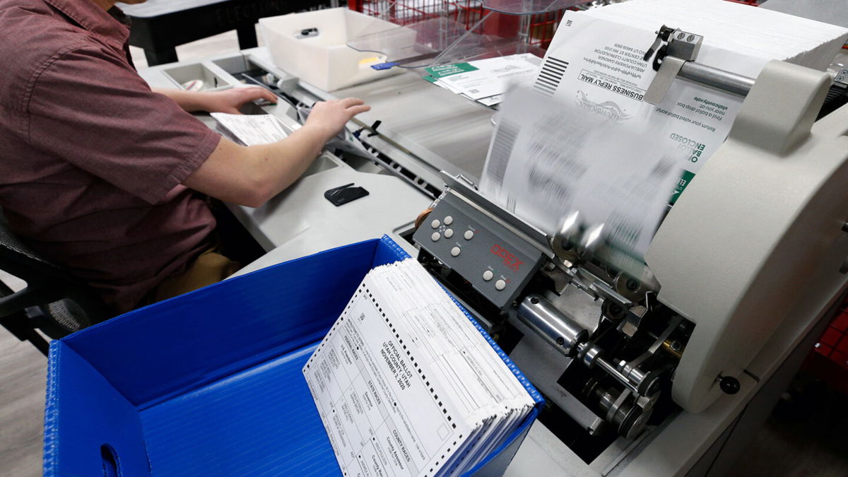<i>George Frey/Getty Images/File</i><br/>An election worker opens envelopes and removes ballots so they can be counted at the election office on October 26
