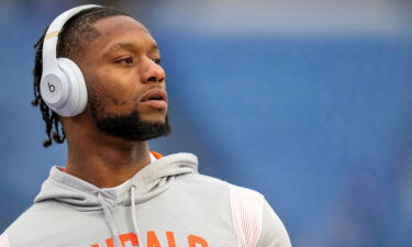 Cincinnati Bengals running back Joe Mixon throws passes with fans during warmups before the NFL divisional playoff game between the Bengals and the Buffalo Bills on January 22 at Highmark Stadium in Orchard Park