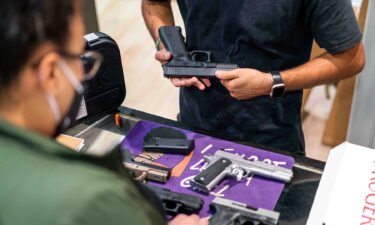 An employee shows a customer a Glock 17 pistol for sale at Redstone Firearms