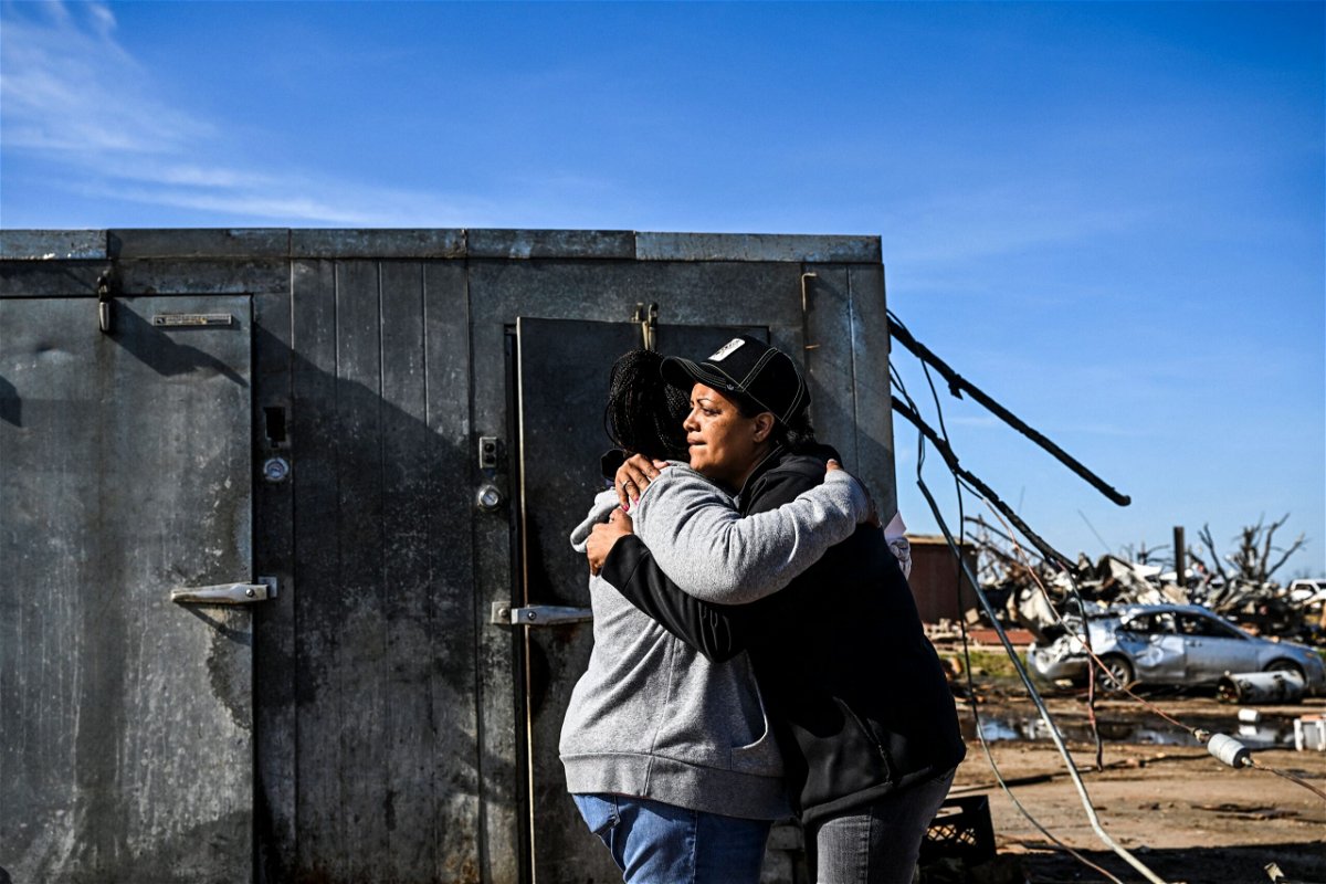 <i>CHANDAN KHANNA/AFP/AFP via Getty Images</i><br/>Tracy Harden (right) hugs Barbara Nell McReynolds-Pinkins near the walk-in cooler where they and seven others took shelter as a tornado destroyed Harden's restaurant in Rolling Fork