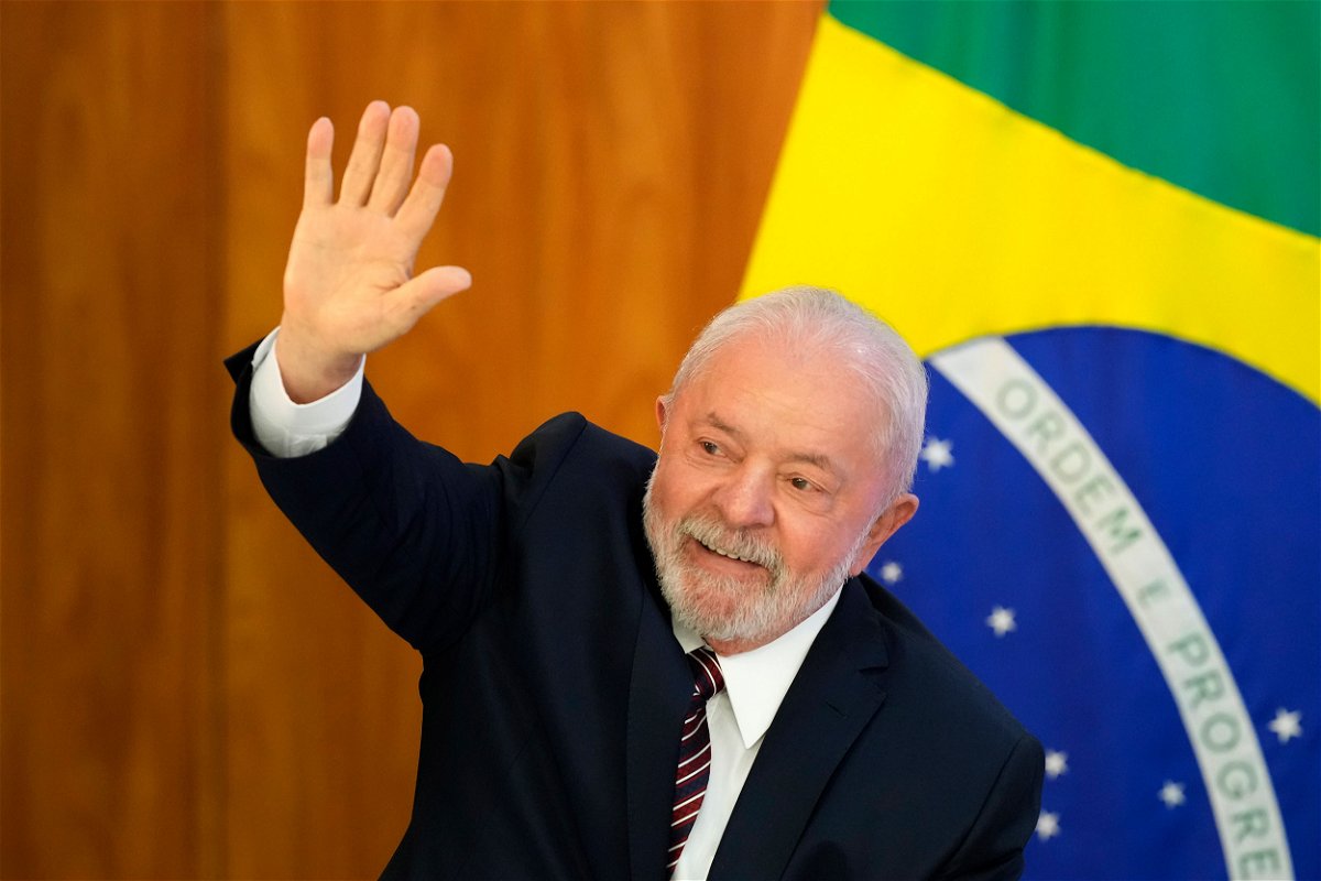 <i>Eraldo Peres/AP</i><br/>Lula waves as he arrives for a ministerial meeting at Planalto Palace in Brasilia on Monday
