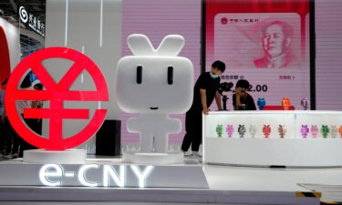 Workers man a booth promoting the digital version of the Chinese yuan in Beijing on September 2