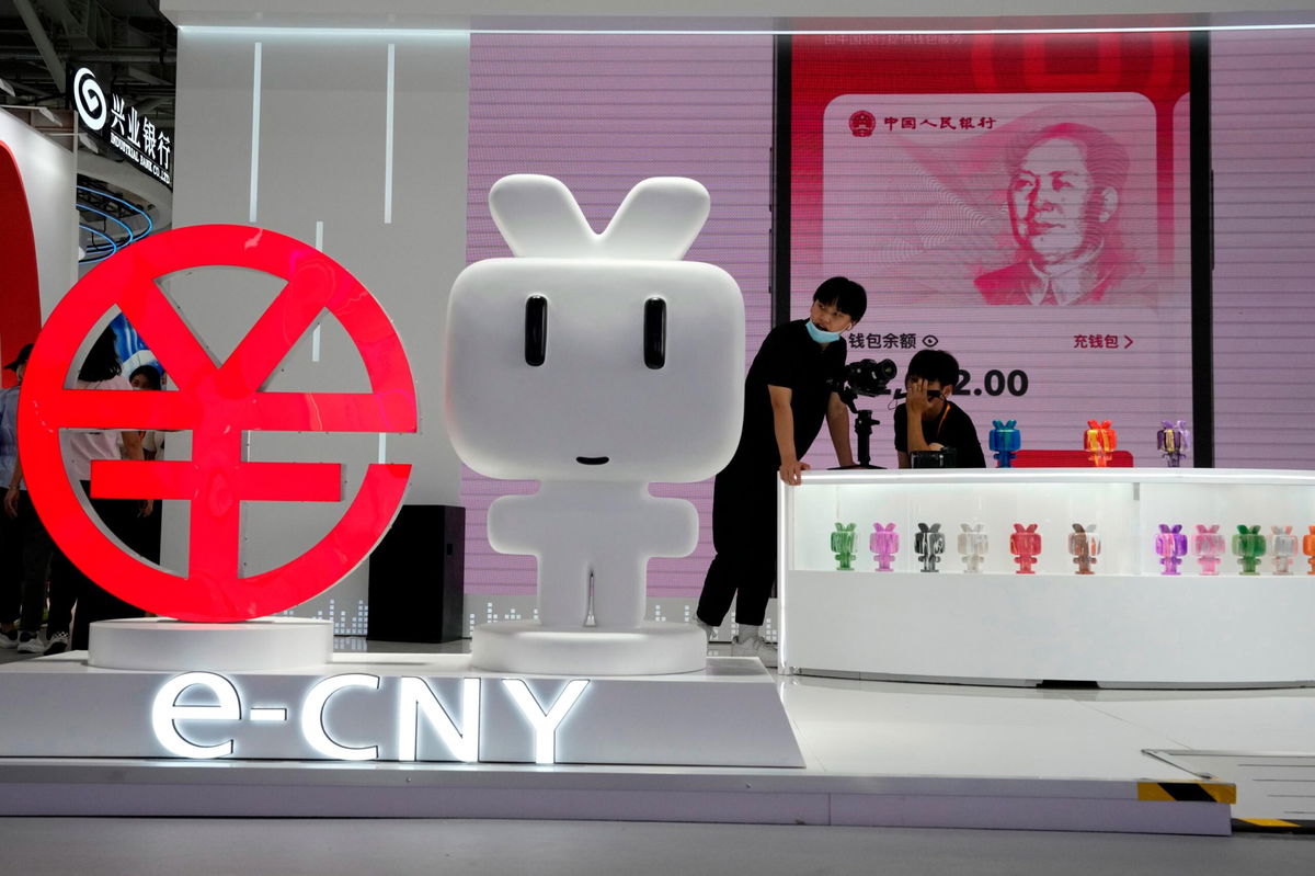 <i>Ng Han Guan/AP/File</i><br/>Workers man a booth promoting the digital version of the Chinese yuan in Beijing on September 2