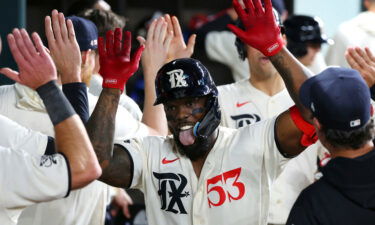 Adolis García celebrates in the dugout after his third home run of the night.