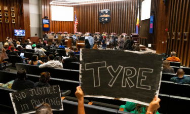 Audience members hold up "no justice in policing" signs honoring Tyre Nichols during a Memphis City Council meeting on April 11.