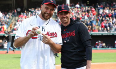 Shane Bieber (right) was poised to catch Kelce's pitch but leapt out of the way to avoid the ball hitting him.