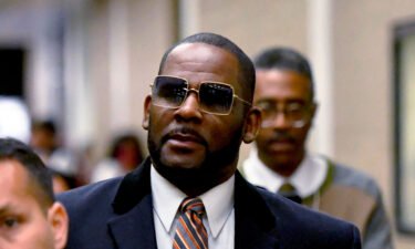 R. Kelly (center) leaves the Daley Center after a hearing in his child support case on May 8