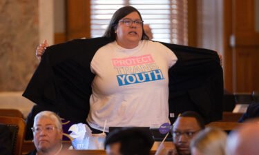 Rep. Heather Meyer shows her "protect trans youth" t-shirt to legislature members following Wednesday's vote to override Gov. Laura Kelly's veto of an anti-trans sports bill.