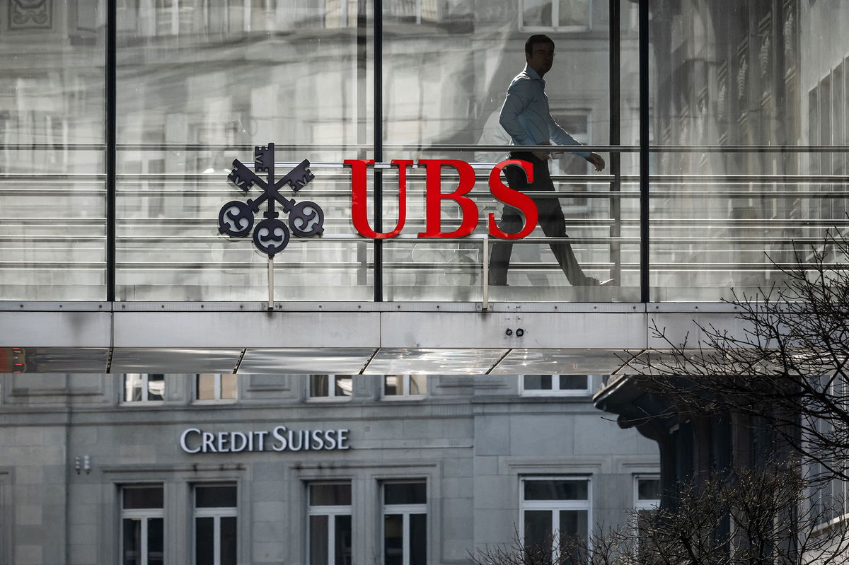 <i>Fabrice Coffrini/AFP/Getty Images</i><br/>A employee is seen in silhouette with sign of Swiss giant banking UBS and a sign of Credit Suisse bank in Zurich on March 20.