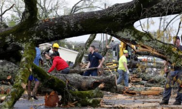 Police and firefighters get help from volunteers clearing downed trees on Keihl Avenue after storms ripped through the area on Friday in Sherwood