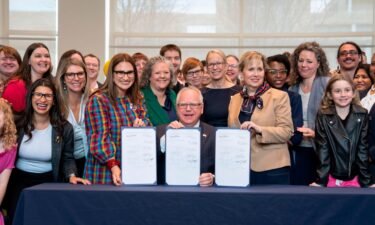 Minnesota Gov. Tim Walz poses with supporters after he signed three progressive priorities