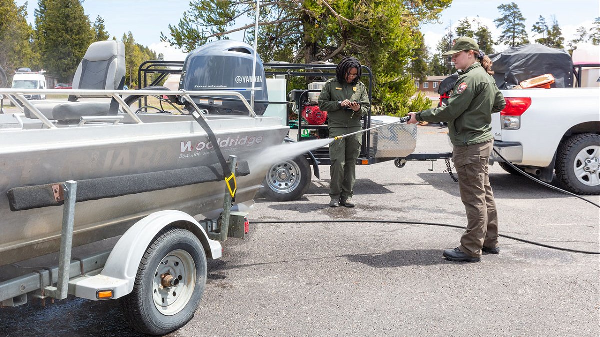 AIS technicians decontaminating a motorized boat and trailer.