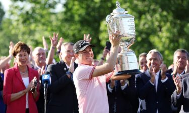 Justin Thomas celebrates with the Wanamaker Trophy after putting in to win on the 18th green