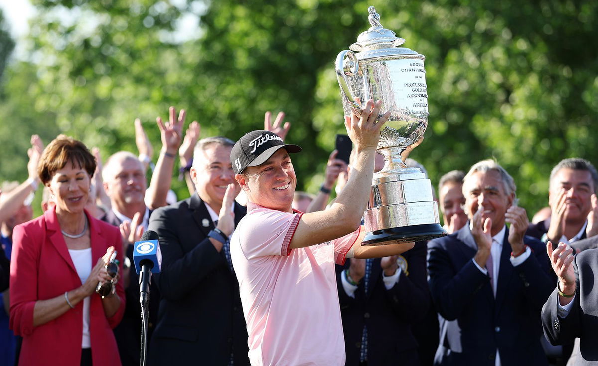 <i>Richard Heathcote/Getty Images</i><br/>Justin Thomas celebrates with the Wanamaker Trophy after putting in to win on the 18th green