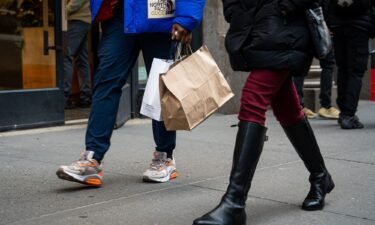 The US economy grew faster in the first quarter than previously estimated. A shopper carries bags in the SoHo neighborhood of New York