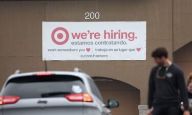 People walk by a hiring sign posted on the exterior of a Target store on April 7 in Novato
