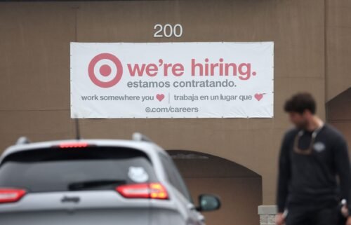 People walk by a hiring sign posted on the exterior of a Target store on April 7 in Novato