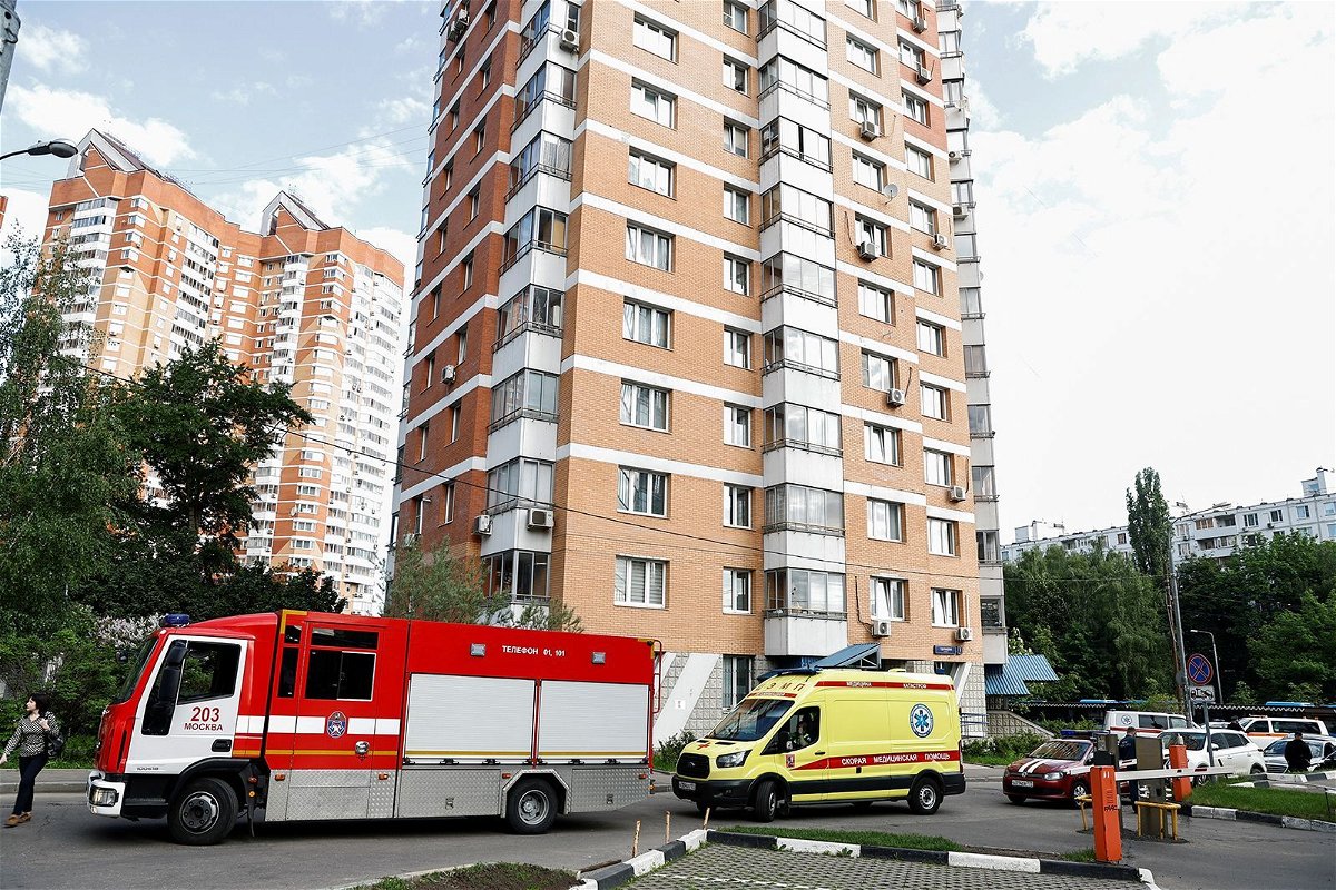 <i>Maxim Shemetov/Reuters</i><br/>An ambulance and firefighting vehicles are parked outside a multi-storey apartment block following a reported drone attack in Moscow