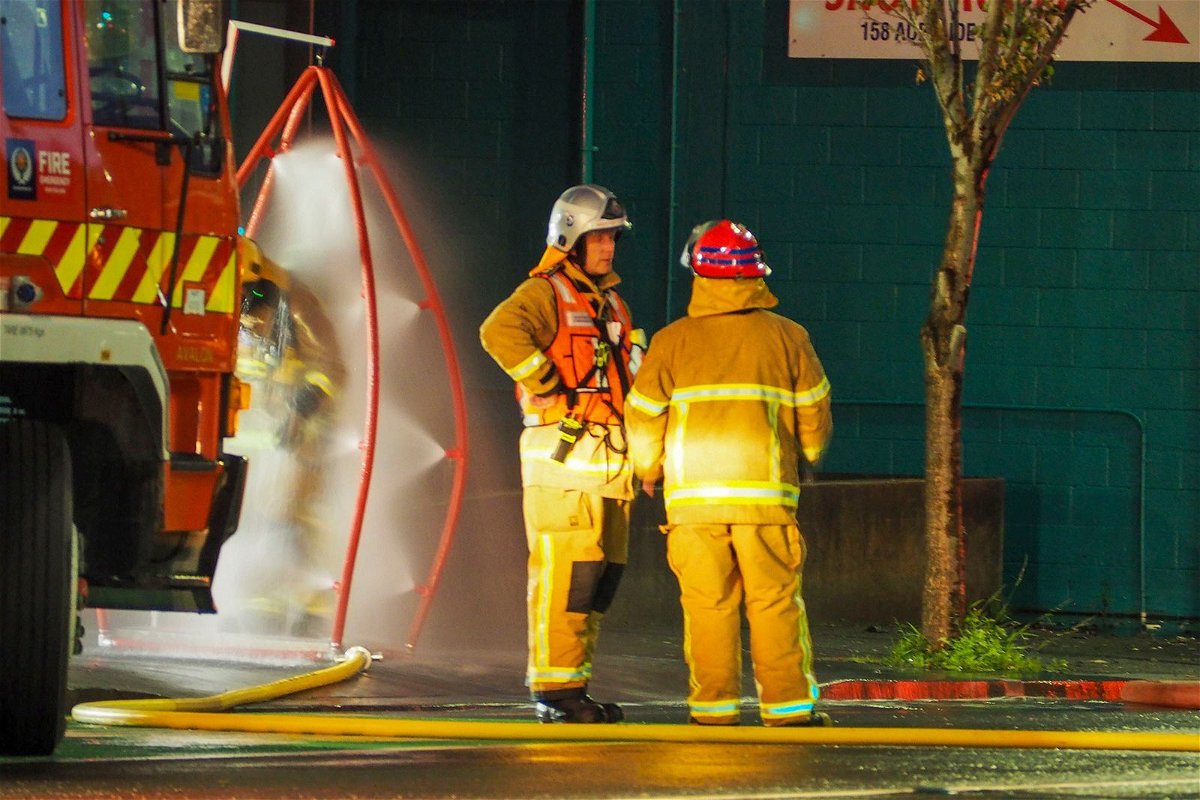 <i>Nick James/AP</i><br/>Firefighters stand outside the hostel where a fire broke out overnight.