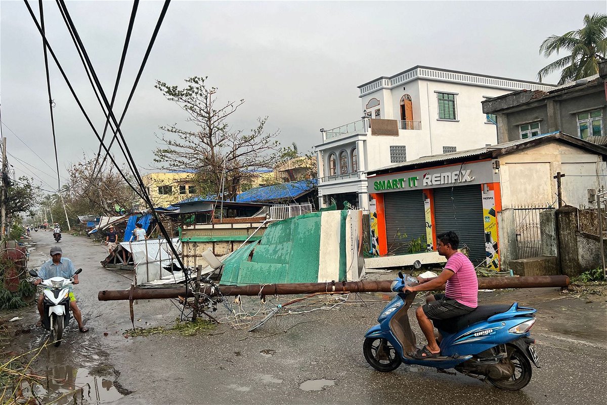<i>Sai Aung Main/AFP/Getty Images</i><br/>Residents ride motorcycles past broken utility poles in Sittwe