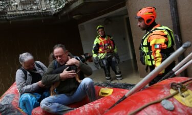 Rescue workers evacuate people and a dog from a flooded house in Faenza on Friday.