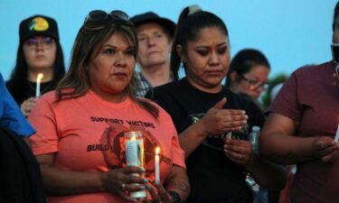 Mourners hold candles Monday during a vigil in Farmington